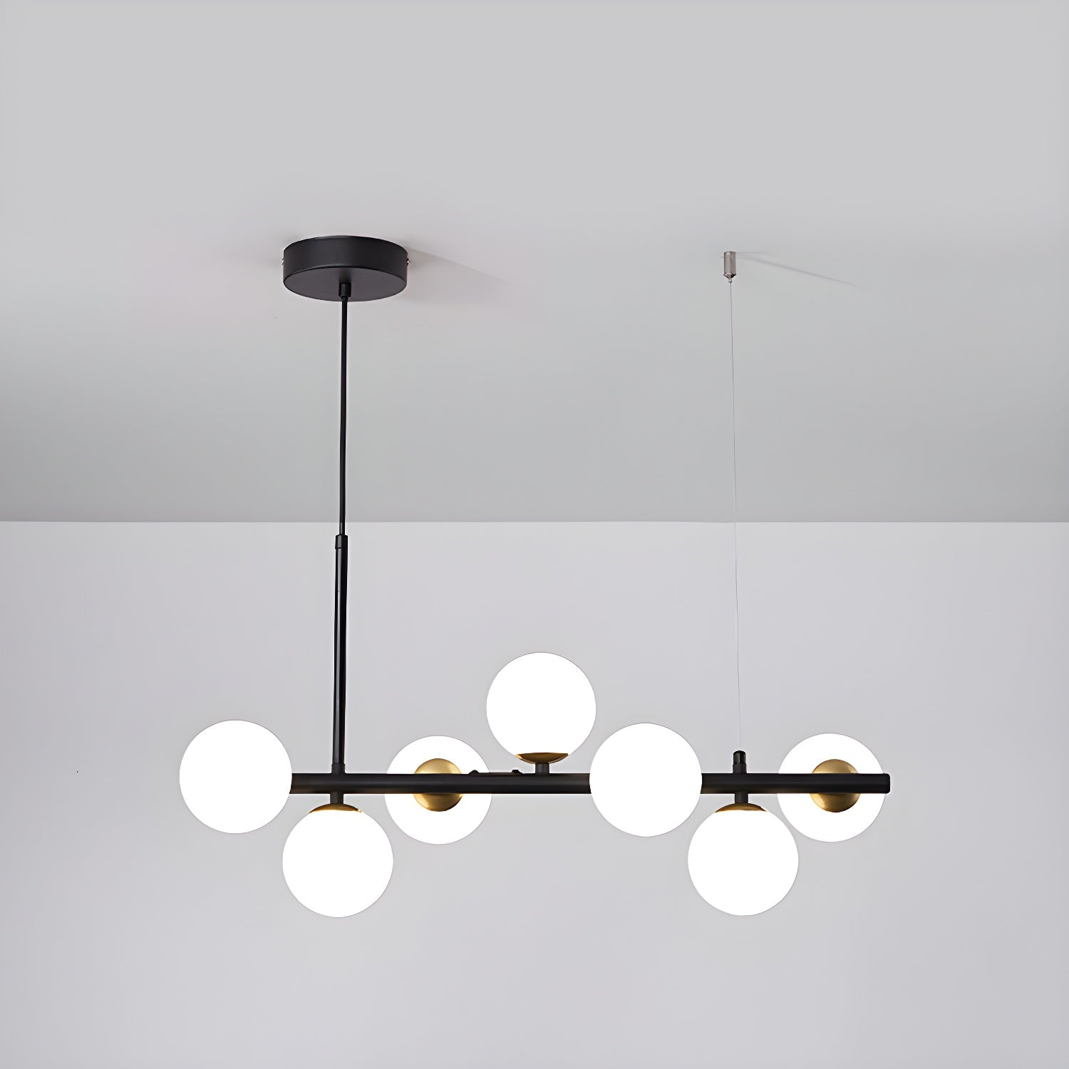 Modern chandelier with adjustable height featuring 11 glass globes and a black metal frame, ideal for living rooms and dining areas. 1