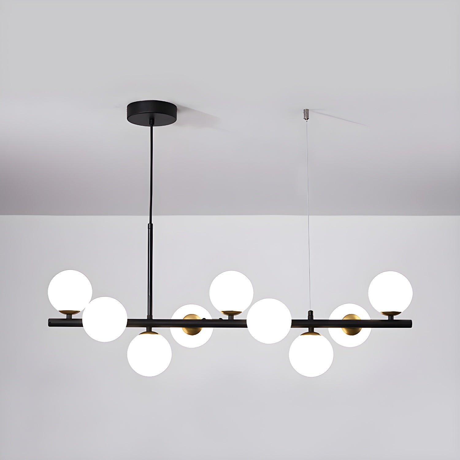 Modern chandelier with adjustable height featuring 11 glass globes and a black metal frame, ideal for living rooms and dining areas. 7