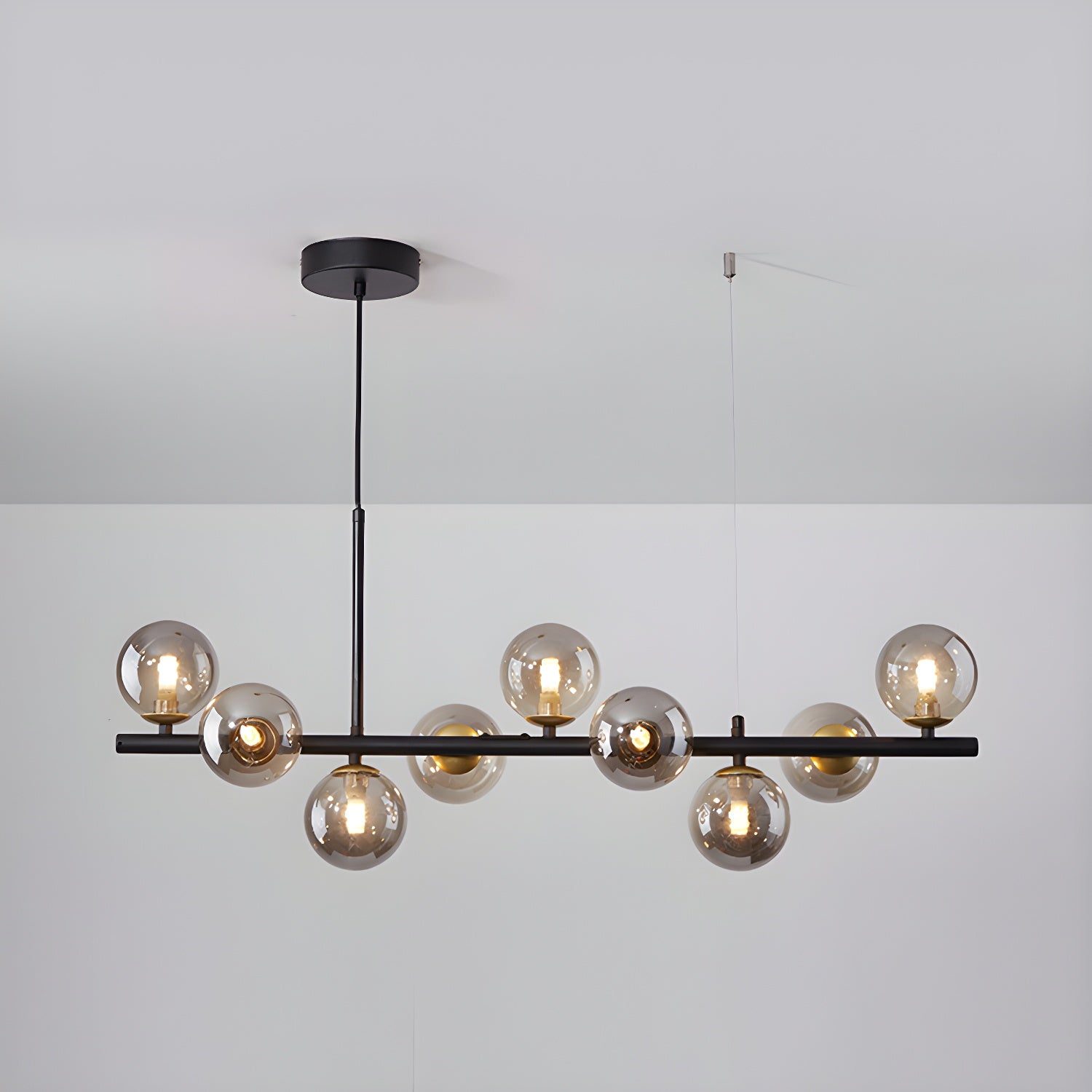 Modern chandelier with adjustable height featuring 11 glass globes and a black metal frame, ideal for living rooms and dining areas. 8